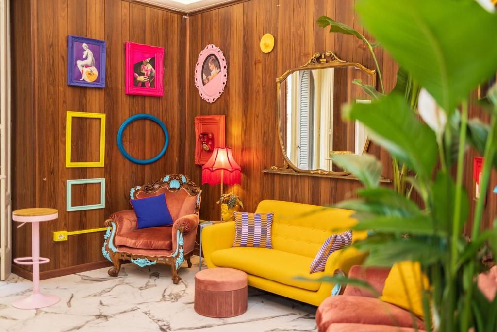 uma sala de estar com um sofá amarelo e um espelho em Santa House em Nápoles