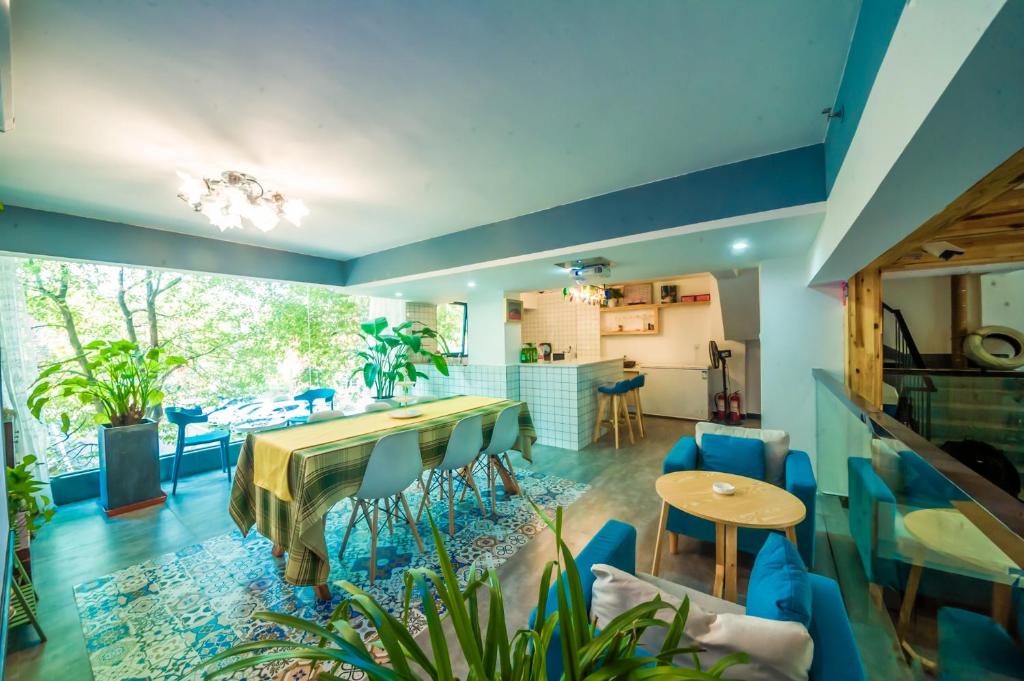 a living room with a table and blue chairs at Yixun Inn in Zhangjiajie