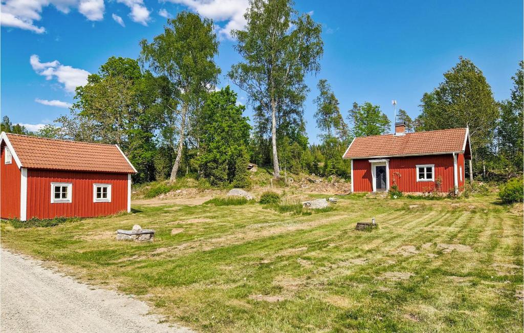 dos edificios rojos en un campo al lado de un camino de tierra en 3 Bedroom Amazing Home In Vrigstad en Vrigstad