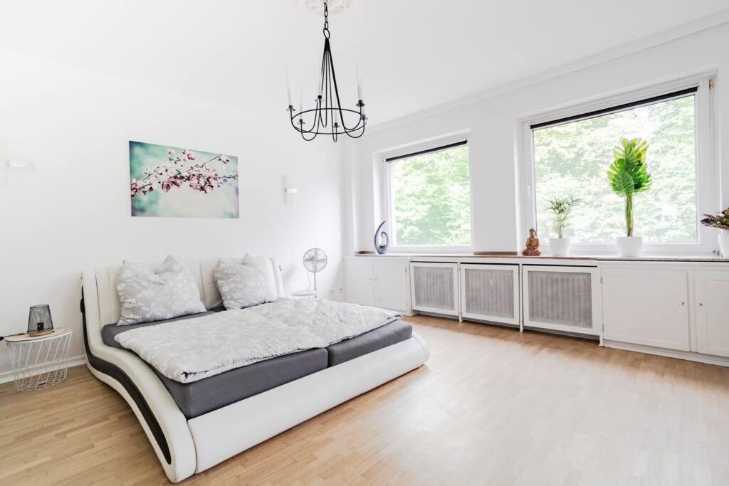 een witte slaapkamer met een groot bed en ramen bij Top Ausstattung Netflix WLAN City Central Station in Krefeld