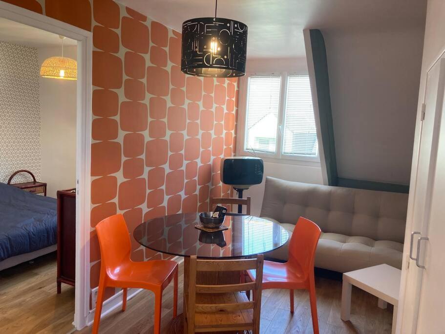 un salon avec une table, des chaises et un canapé dans l'établissement Confort et charme des 70's dans le centre piéton, à Vannes