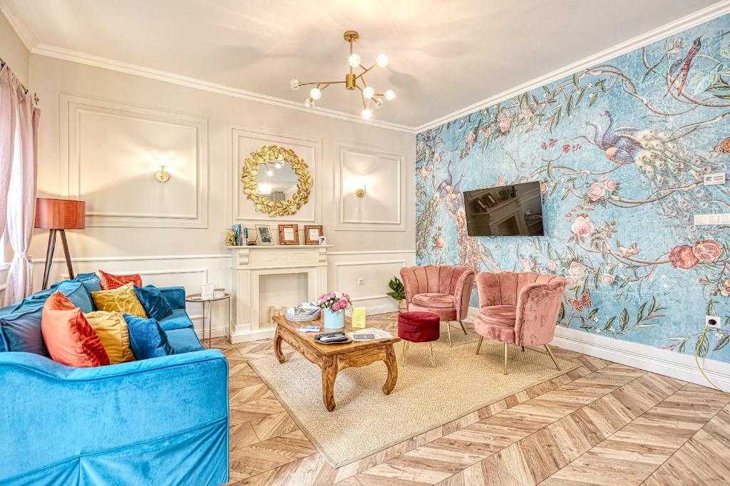 a living room with a blue couch and a table at The Doors Boutique Apartments in Mosonmagyaróvár