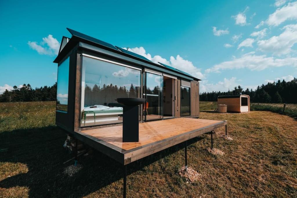a tiny house with a window on a field at TinyHouse Rumcajs in Malšín