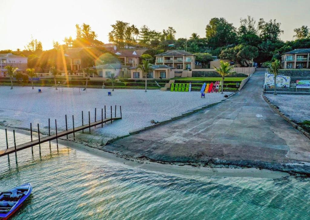 a boat in the water next to a beach at Bilene Lodge by Dream Resorts in Vila Praia Do Bilene