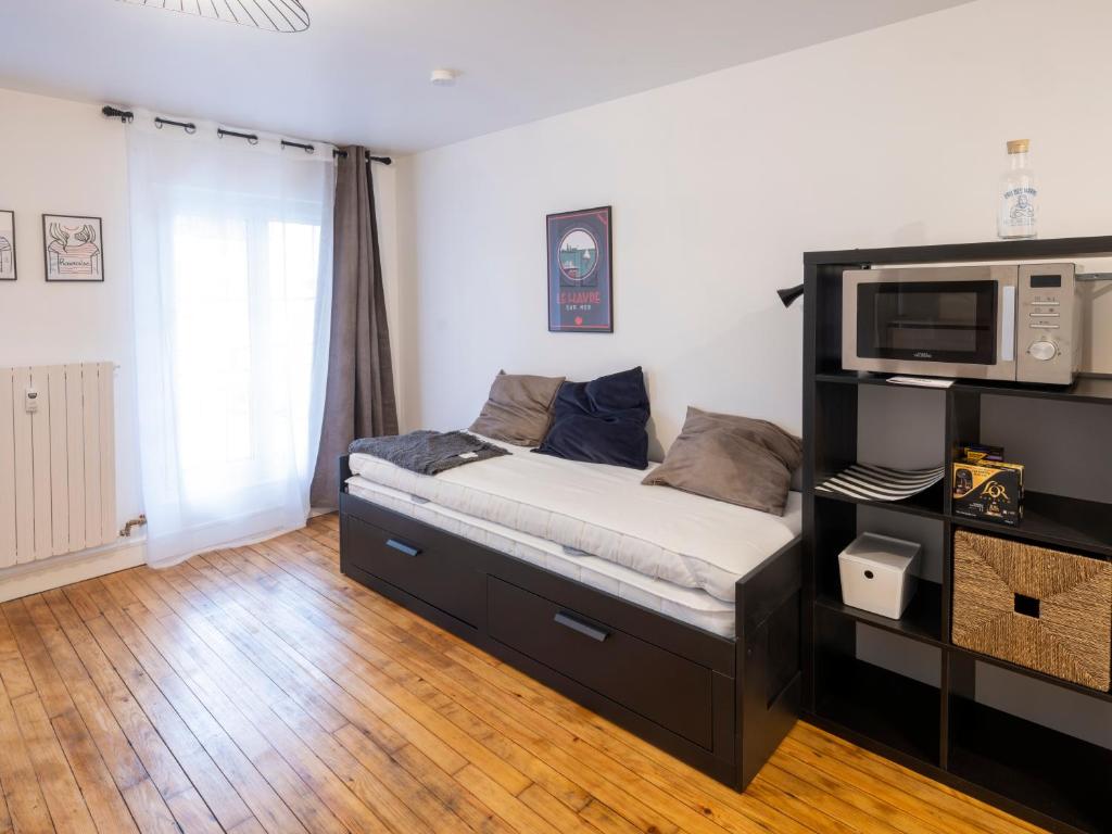 um quarto com uma cama com um micro-ondas em Résidence GABRIELLE em Le Havre