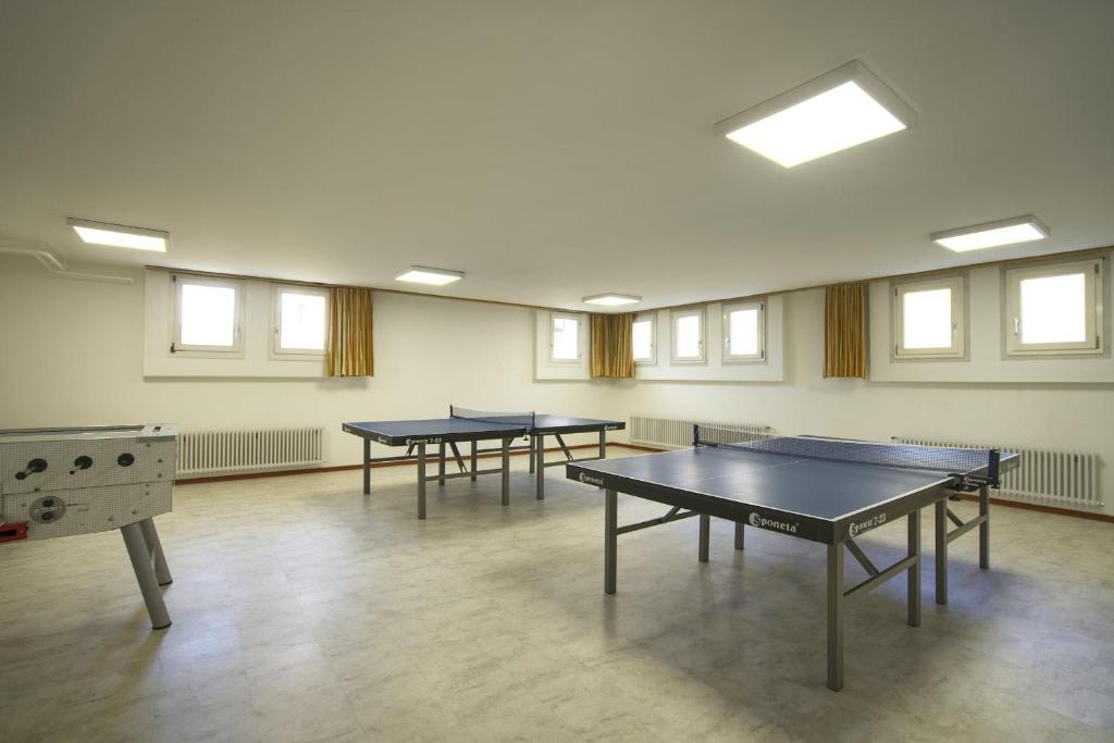 3 tavoli da ping pong in una stanza con finestre di Residenza Lagrev 1 Zimmerwohnung Nr 118 - Typ 12B - 1 Etage - Ost a Sils Maria