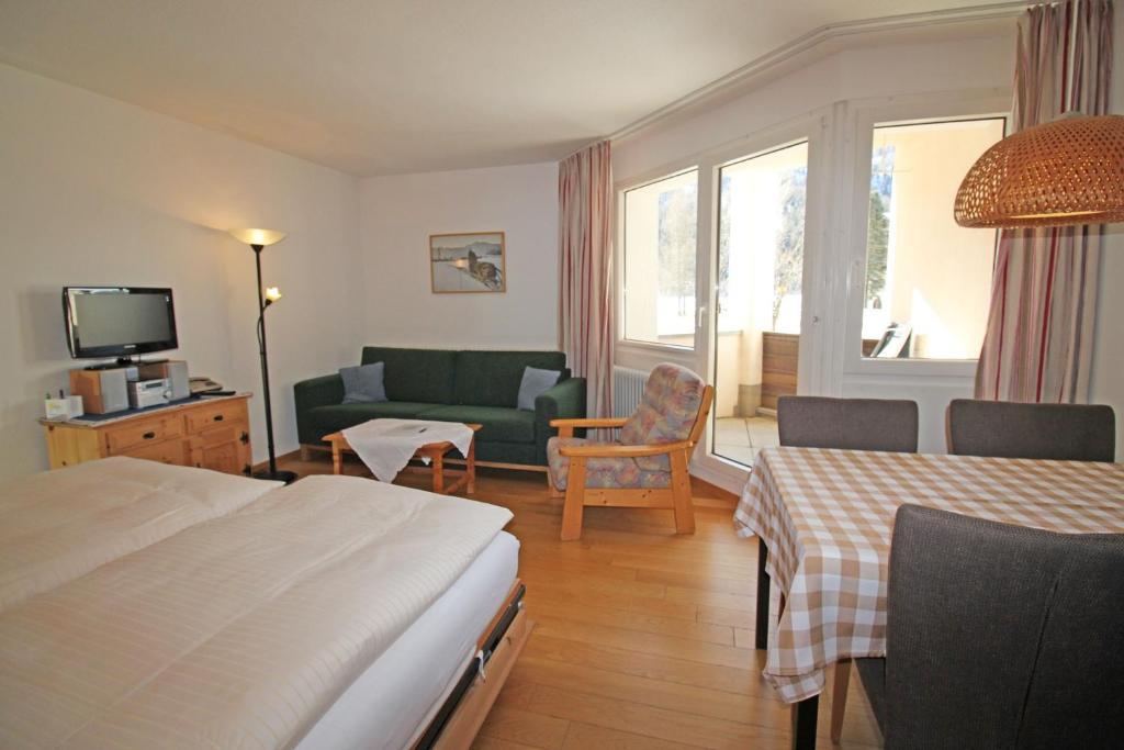 Una habitación de hotel con una cama y una sala de estar. en Residenza Lagrev 1 Zimmerwohnung - Nr 003 - Typ 12A - Hochparterre - Süd, en Sils-Maria