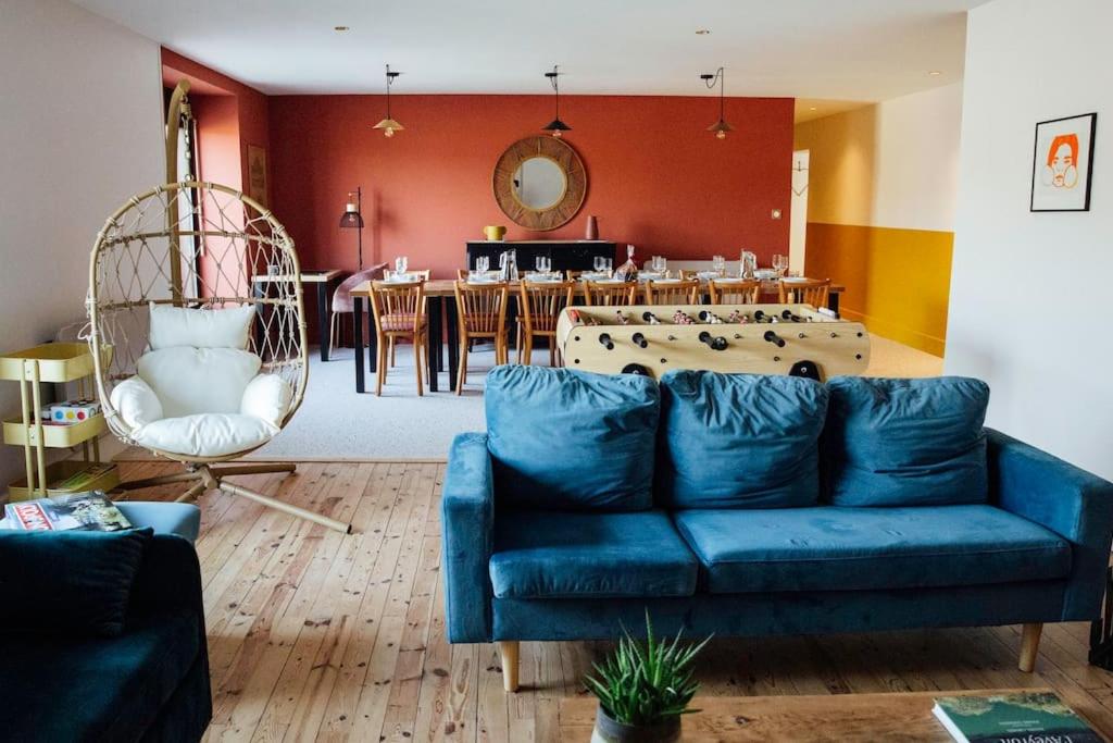 uma sala de estar com um sofá azul e uma mesa em Gîte Trou Life em Bozouls