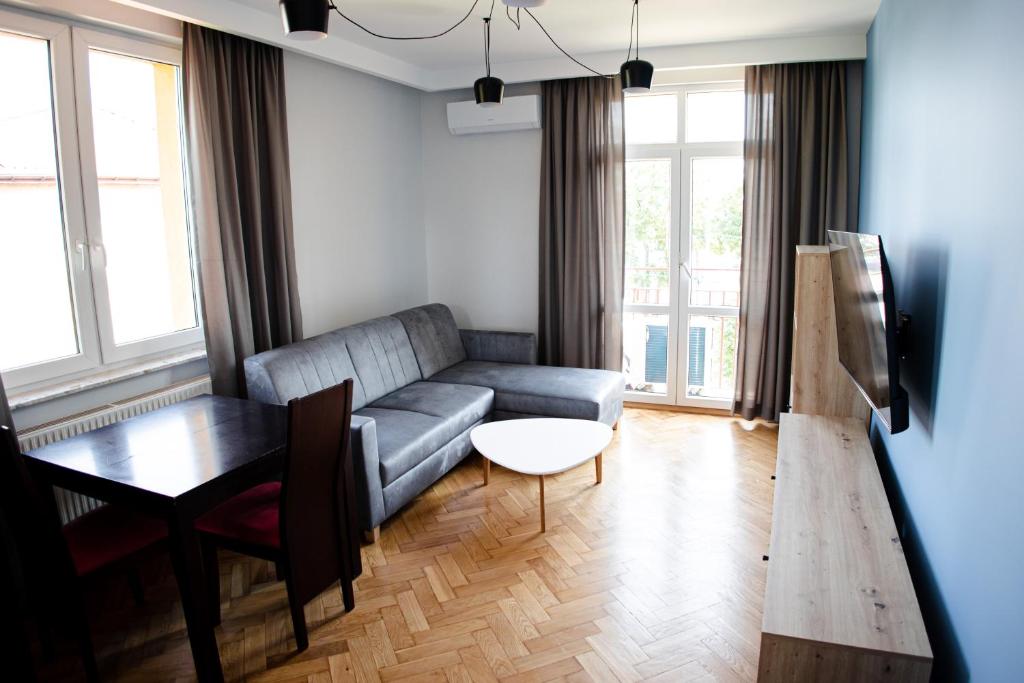 a living room with a couch and a table at Sowi Loft in Hajnówka