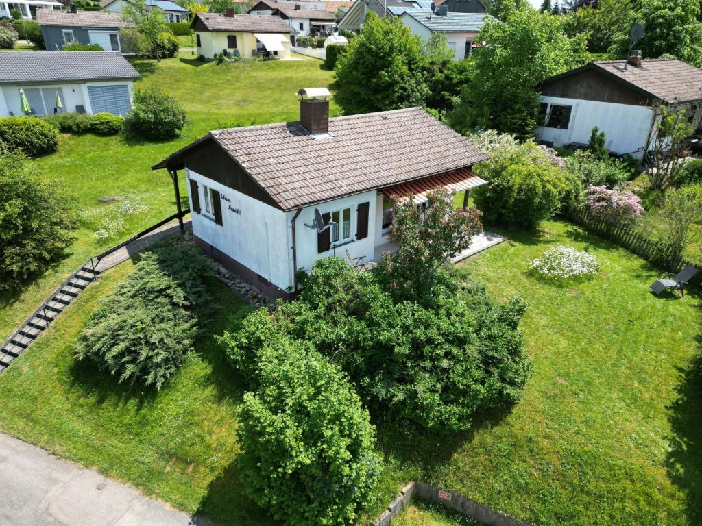 una pequeña casa blanca en un patio con arbustos en Holiday Home Schöne Aussicht by Interhome, en Dittishausen