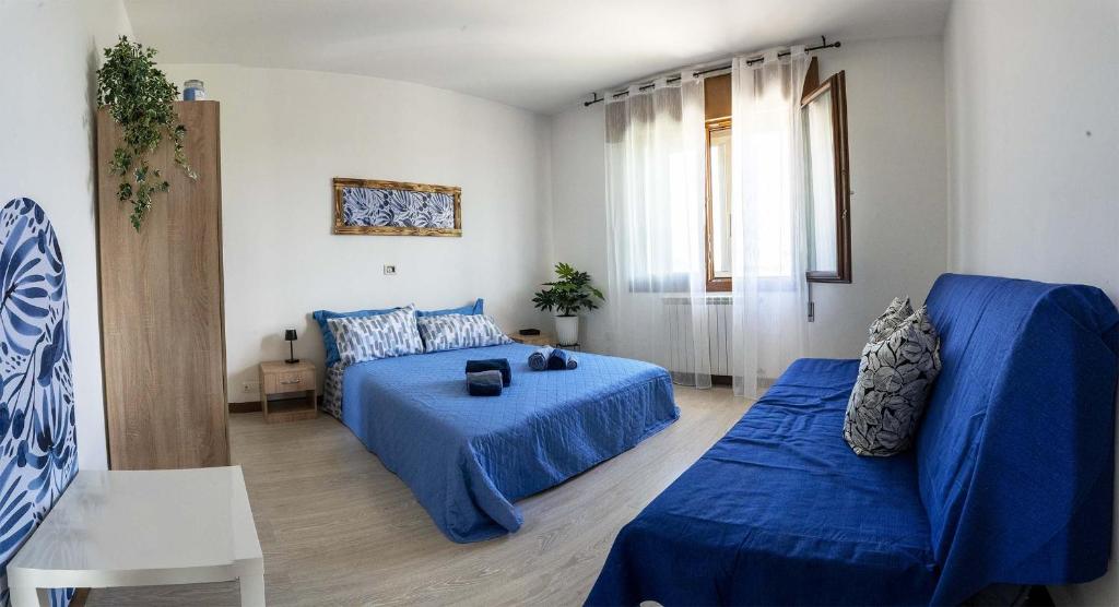een woonkamer met een blauw bed en een bank bij Ornella's apartment - Relax near Venice 