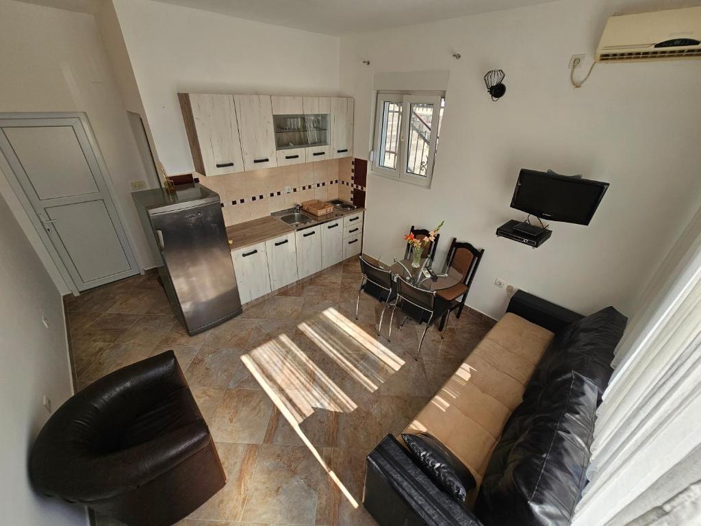 een woonkamer met een bank en een tafel en een keuken bij Apartmani Vanja 2 in Kotor