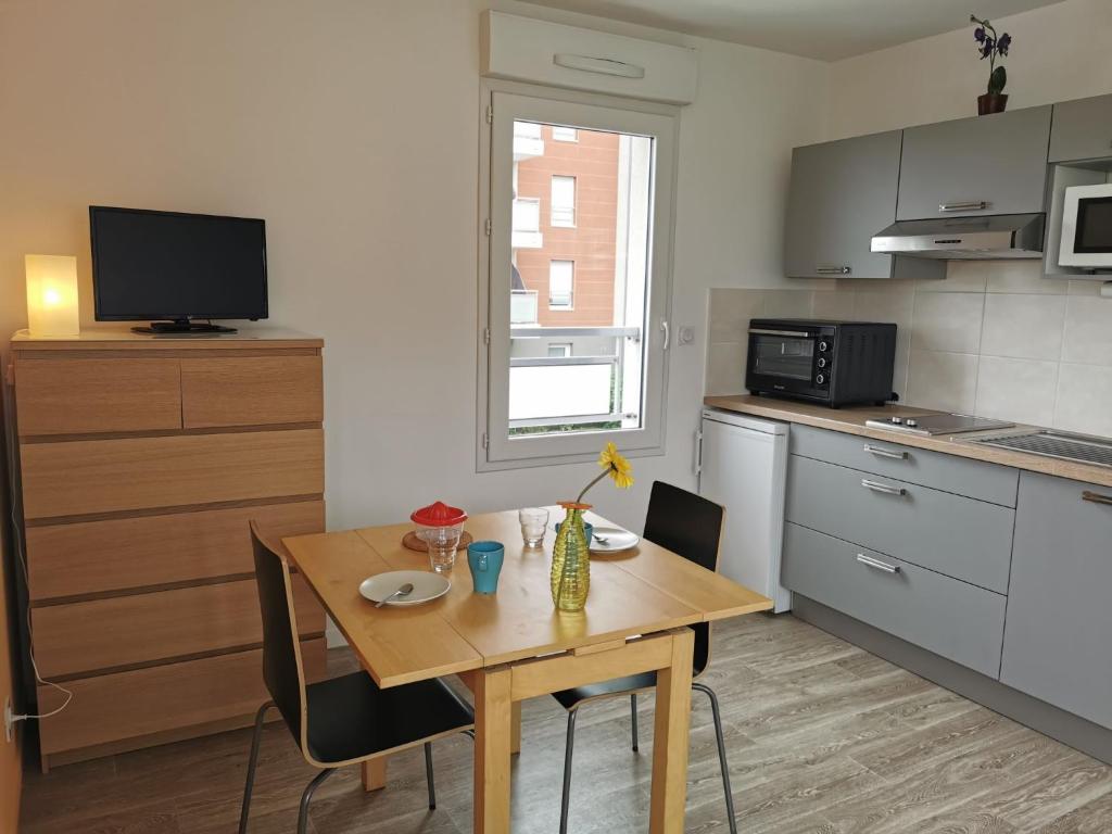 a small kitchen with a wooden table and a dining room at Studio Apsara by Interhome in Saint Malo