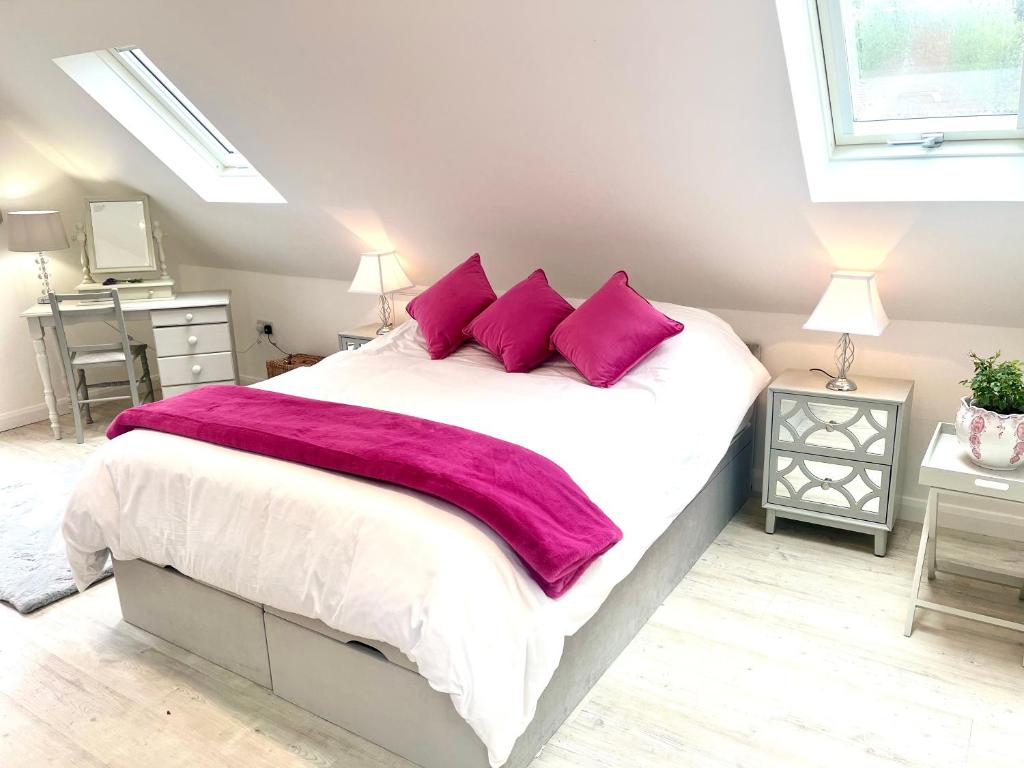 a bedroom with a large bed with purple pillows at The Nest in Rake