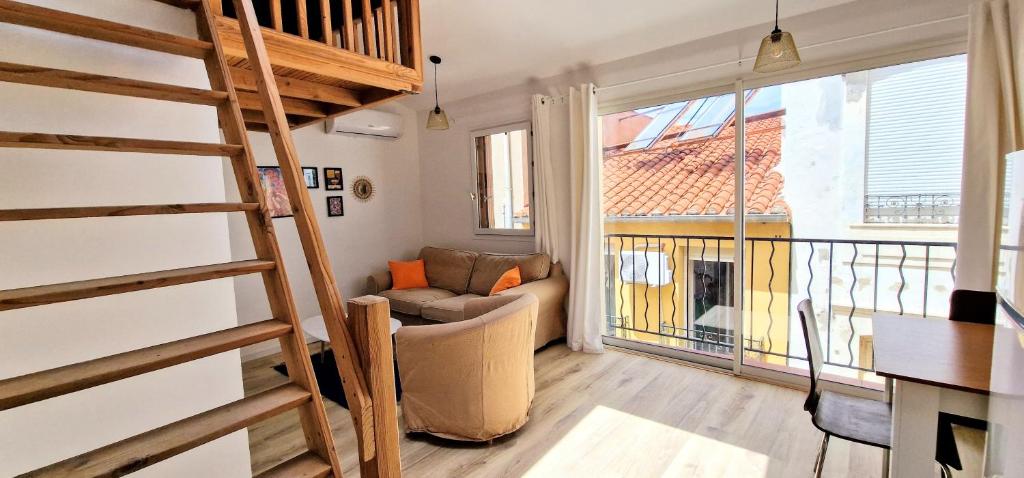 ein Wohnzimmer mit einer Treppe und einer Couch in der Unterkunft Appartement en bord de mer 3 in Banyuls-sur-Mer