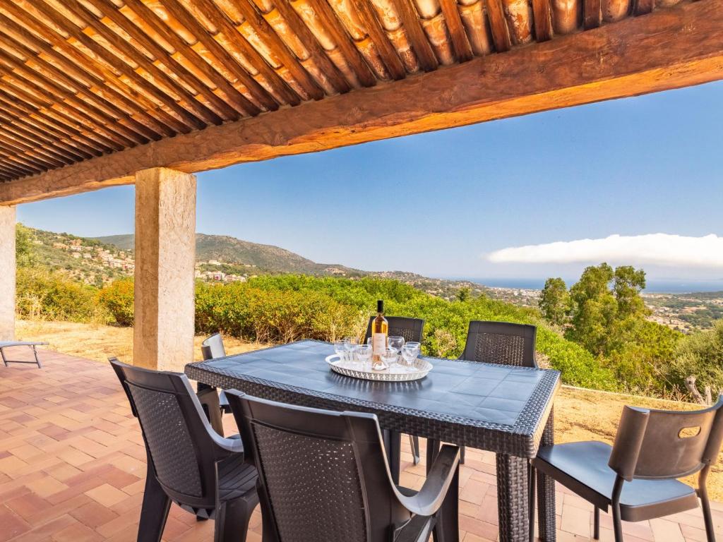 un tavolo e sedie su un patio con vista di Holiday Home Mont des Roses by Interhome a Bormes-les-Mimosas