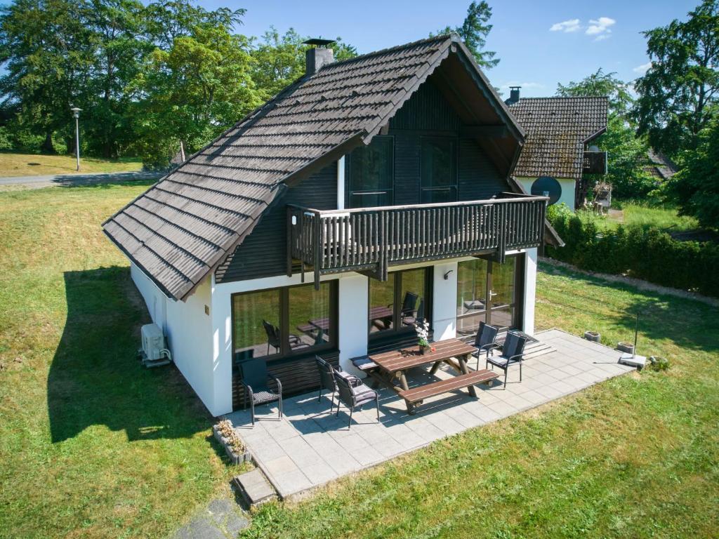 una pequeña casa con terraza y mesa de picnic en Holiday Home Am Sternberg 97 by Interhome, en Frankenau
