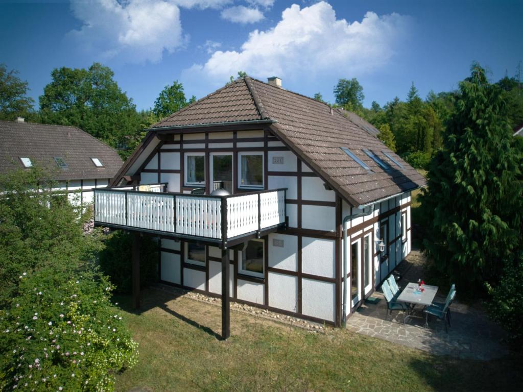 ein kleines Haus mit einer Veranda und einem Balkon in der Unterkunft Holiday Home Am Sternberg 224-226 by Interhome in Frankenau