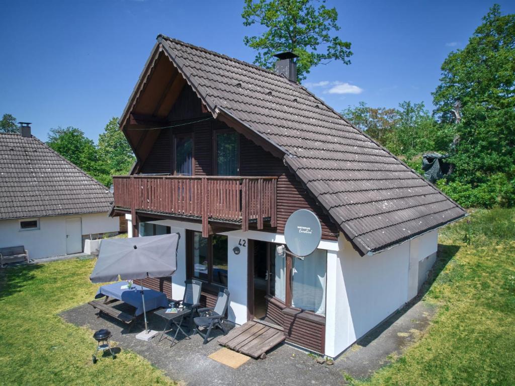 uma cabana de madeira com um deque e uma casa em Holiday Home Am Sternberg 42 by Interhome em Frankenau