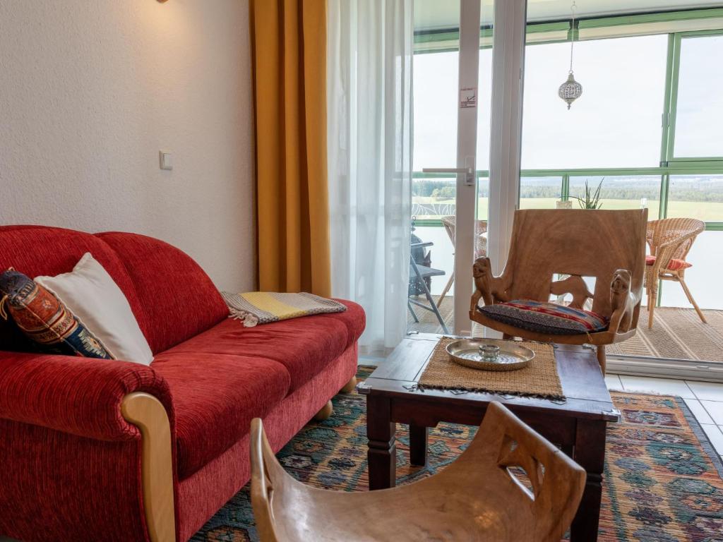 een woonkamer met een rode bank en een tafel bij Apartment F 32 by Interhome in Dittishausen