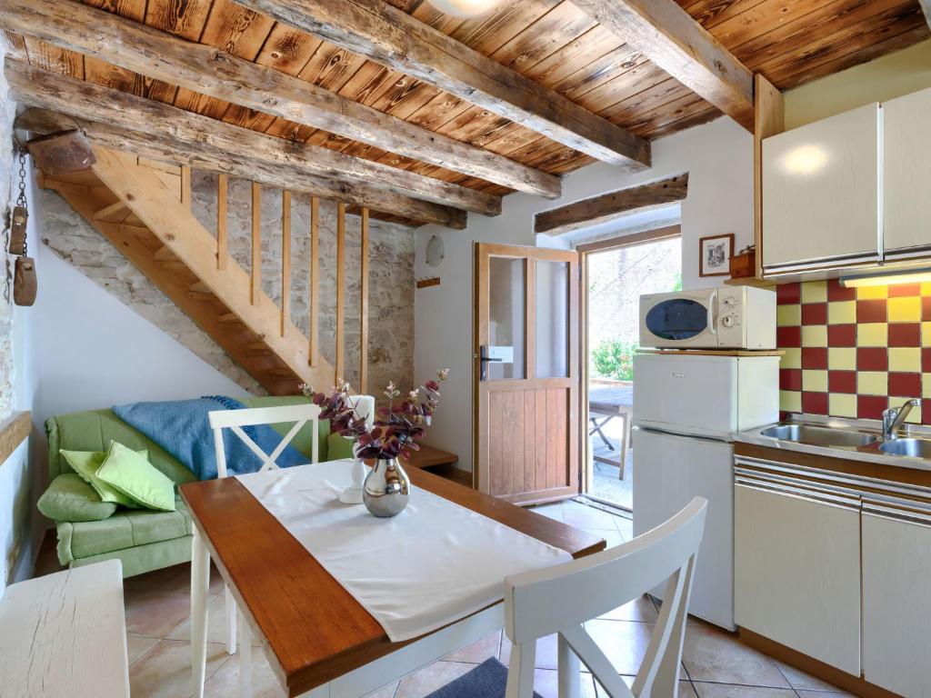 kuchnia i jadalnia ze stołem oraz kuchnia i salon w obiekcie Holiday Home Pinia I by Interhome w mieście Kaštelir