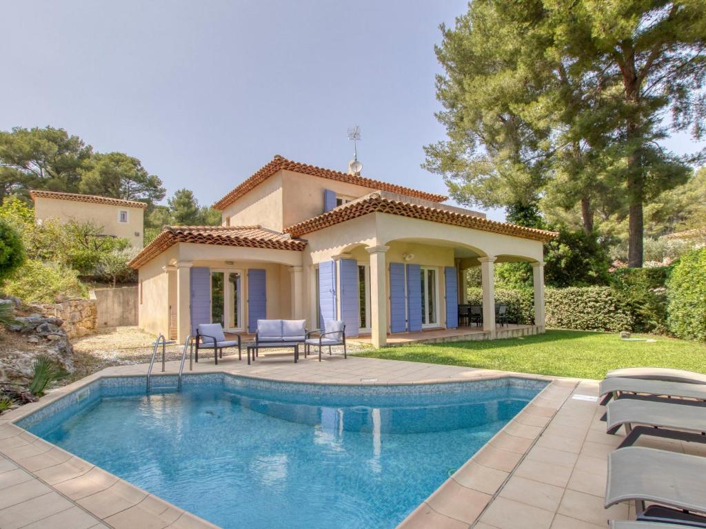 a villa with a swimming pool in front of a house at Villa Le Puit des Oliviers I by Interhome in La Cadière-dʼAzur