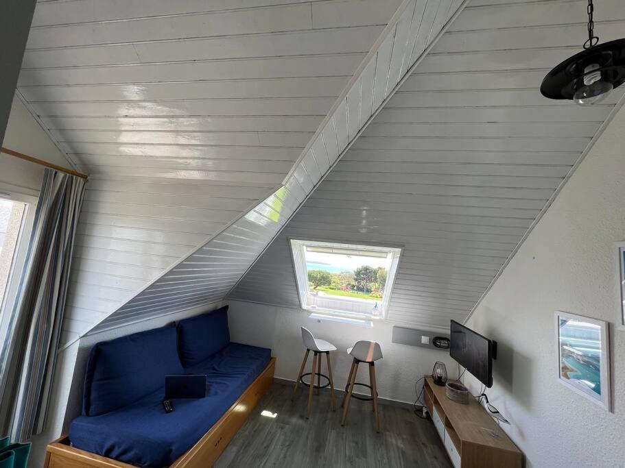 アルゾンにあるAppartement avec vue merのリビングルーム(屋根裏部屋、青いソファ付)