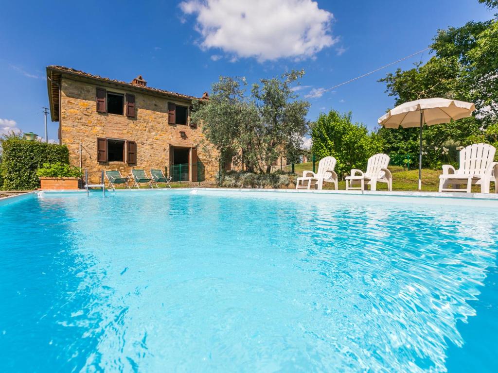 una piscina con sedie e ombrellone di fronte a una casa di Holiday Home Il Laghetto by Interhome a Pergine Valdarno