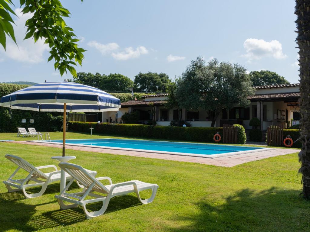 Dos sillas y una sombrilla junto a una piscina. en Holiday Home Dolce Vita-4 by Interhome, en Bolsena