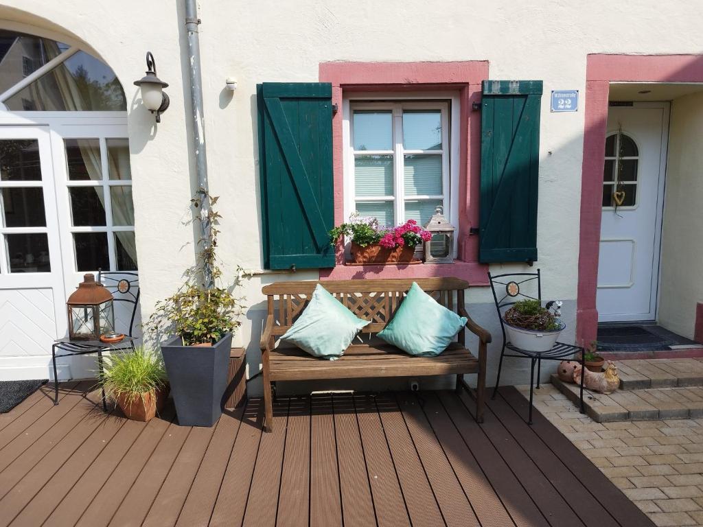 eine Bank auf einer Veranda mit einem Fenster und Pflanzen in der Unterkunft Ferienwohnung Heisig in Leiwen