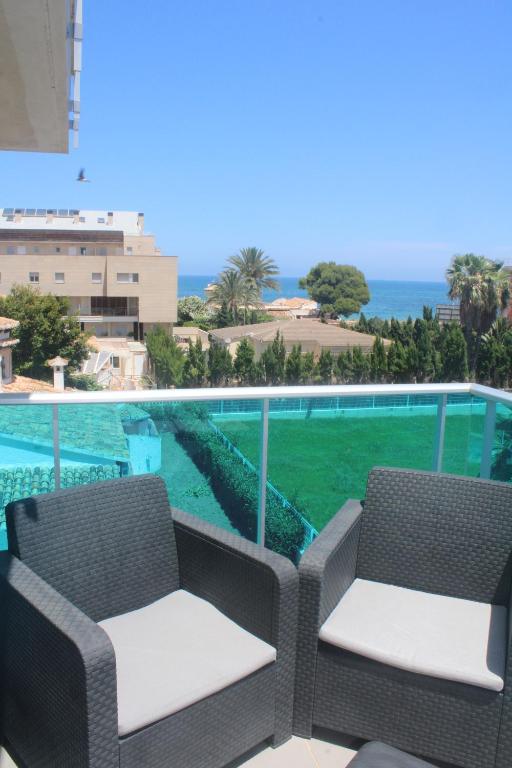 a balcony with two chairs and a view of the ocean at Apto. Burbujas - Marenia´s Dream in Denia