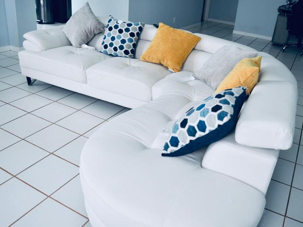 ein weißes Sofa mit Kissen darauf im Zimmer in der Unterkunft WORLD CUP! LUXURY 3Bd ENTIRE HOME POMPANO BEACH- AIRPORT-BEACH-GOLF in Margate