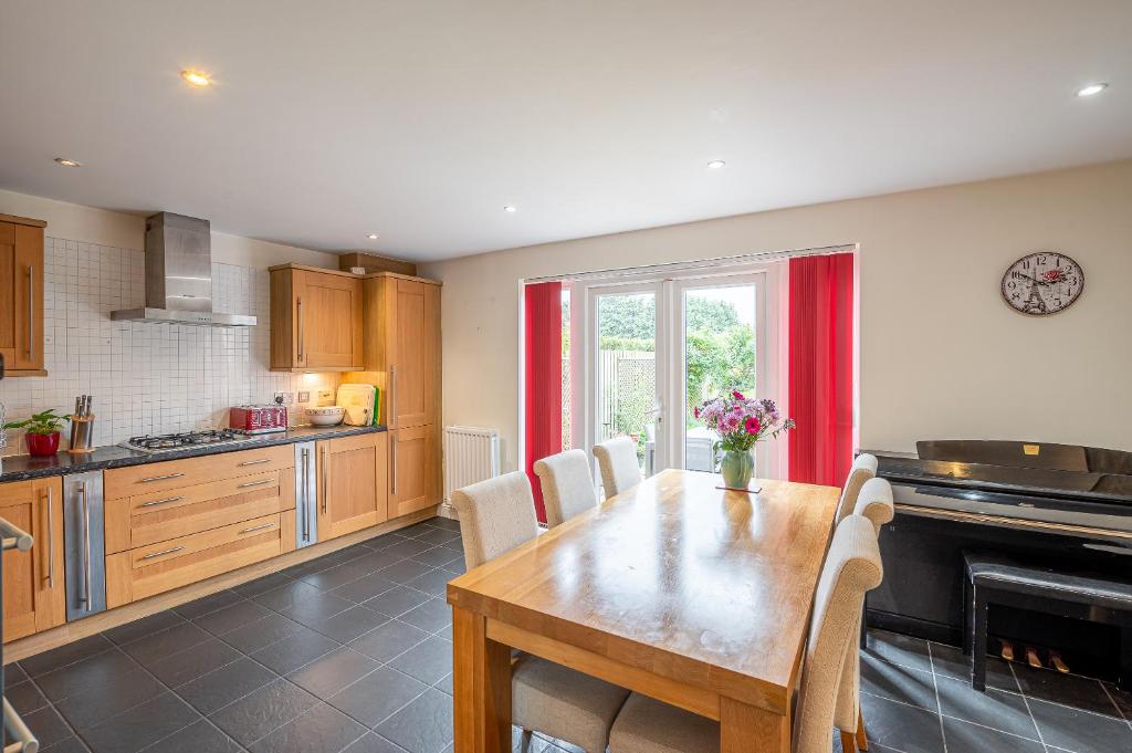 a kitchen with a wooden table and a dining room at 4 Bedroom House in Addingham Ilkley in Addingham