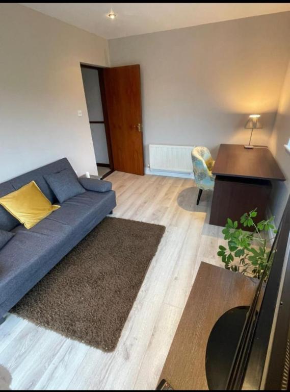 Una sala de estar con un sofá azul y un escritorio. en Ard Falcon, en Cork