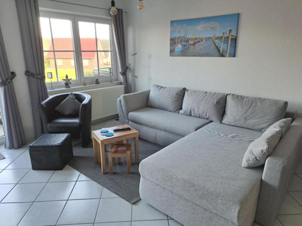 a living room with a couch and a table at Haus Sonnenstrahl 11 in Dorum-Neufeld