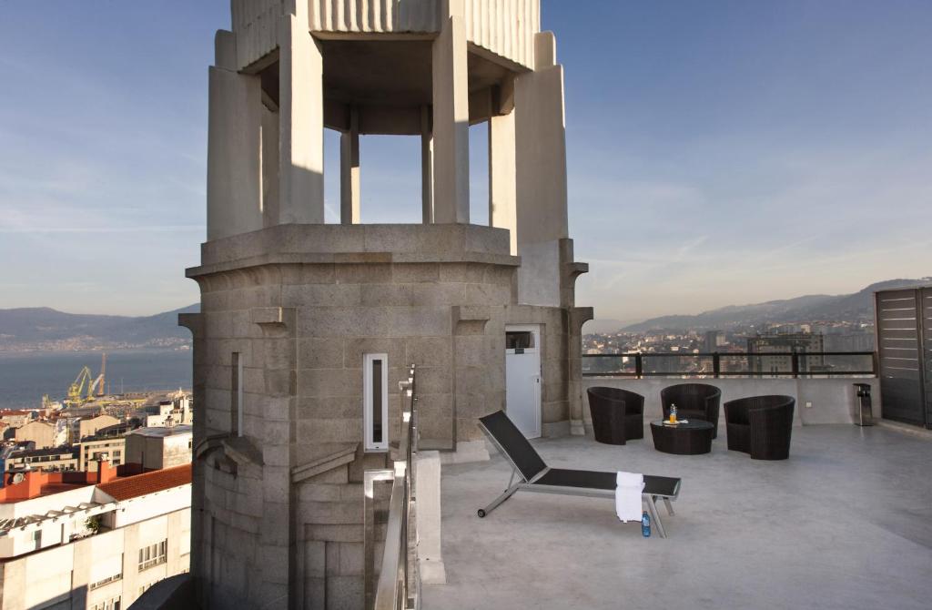 a balcony with a table and chairs on a building at Zenit Vigo in Vigo