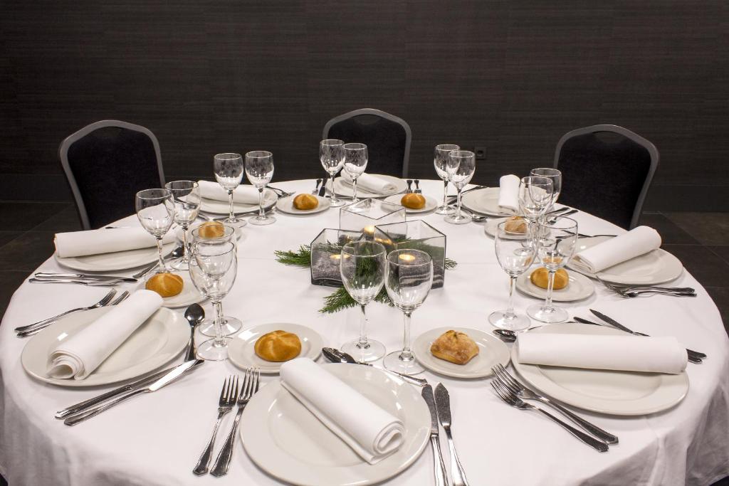 a table with white plates and wine glasses on it at Zenit Vigo in Vigo