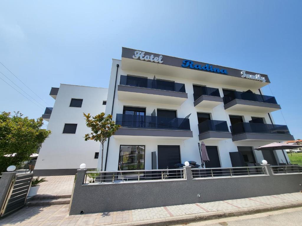 a white building with a sign on top of it at RADINA FAMILY in Kallithea Halkidikis