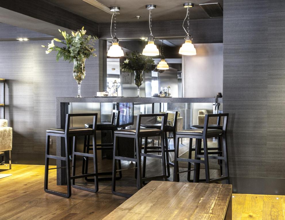 a bar in a restaurant with black stools at Zenit Vigo in Vigo