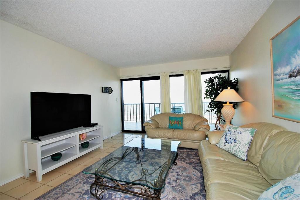 uma sala de estar com um sofá e uma televisão em Franke Plaza unit #1504 condo em South Padre Island