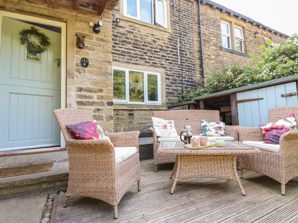 a patio with wicker chairs and a table on a deck at Ludd Brook Cottage in Halifax