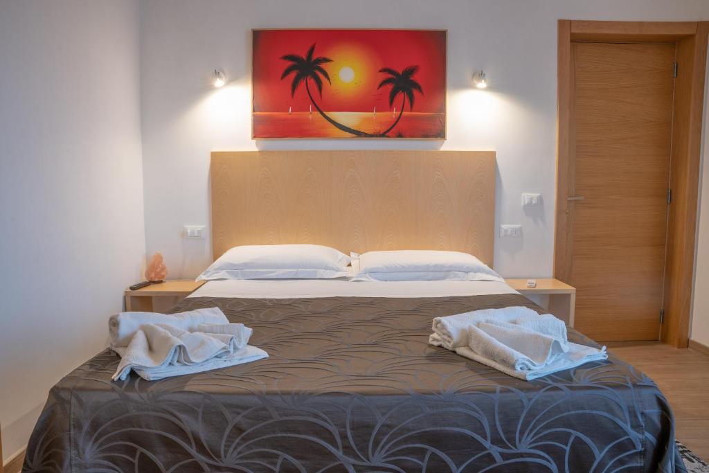 una camera da letto con un letto e asciugamani di B&B Alle Calende Greche a Martignano