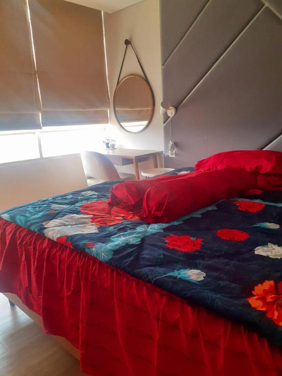 een bed met een rood en blauw dekbed in een slaapkamer bij Apartemen Skandinavia Tangerang in Karawaci