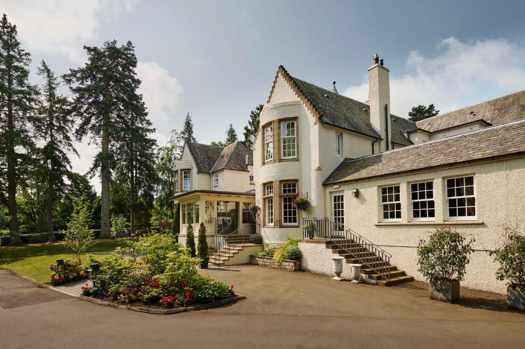 una grande casa bianca con scale che la conducono di Cairn Lodge ad Auchterarder