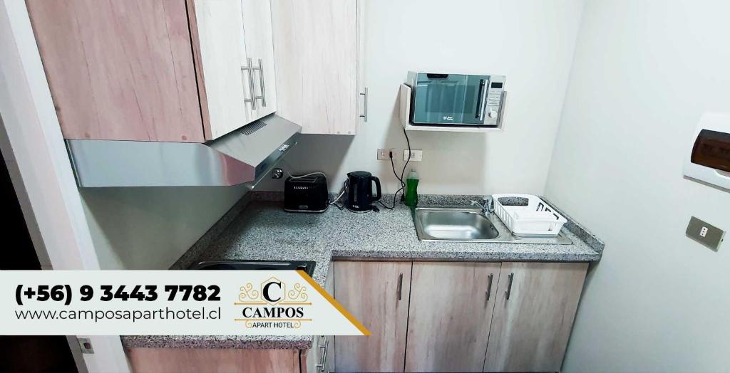 a small kitchen with a sink and a microwave at Hostal Campos Rancagua in Rancagua