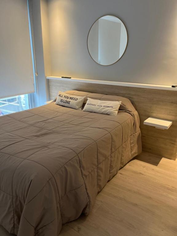 a bedroom with a bed with a mirror on the wall at Ambientes Baires in Buenos Aires