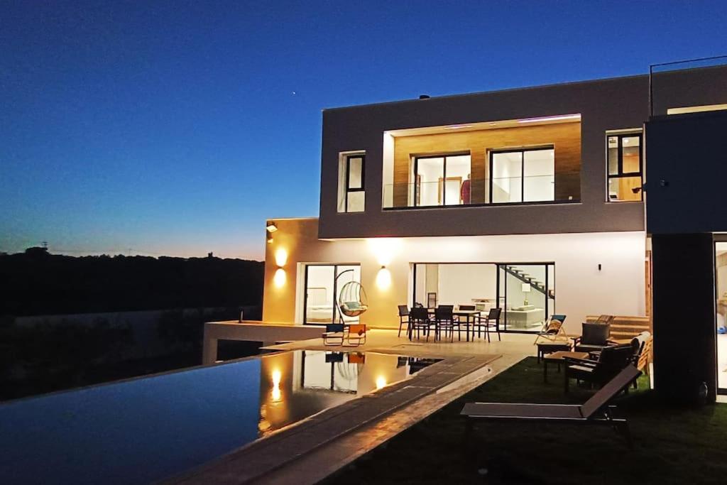 a house with a swimming pool in front of it at Splendide maison de campagne avec piscine et vue panoramique. in El Maamoura