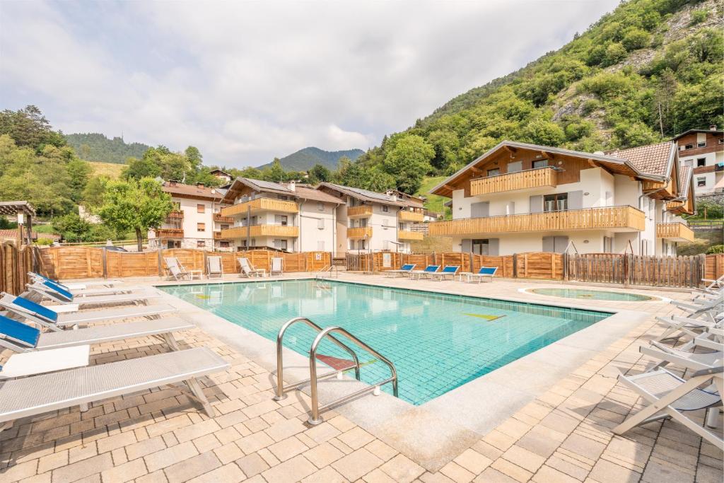 a swimming pool with lounge chairs and a resort at Residence Alessio in Ledro