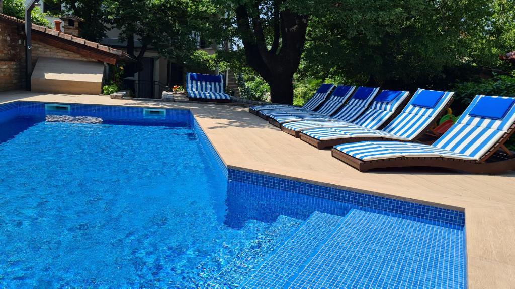 een groep stoelen naast een zwembad bij Villa Amalia Apartment 2 in Malinska
