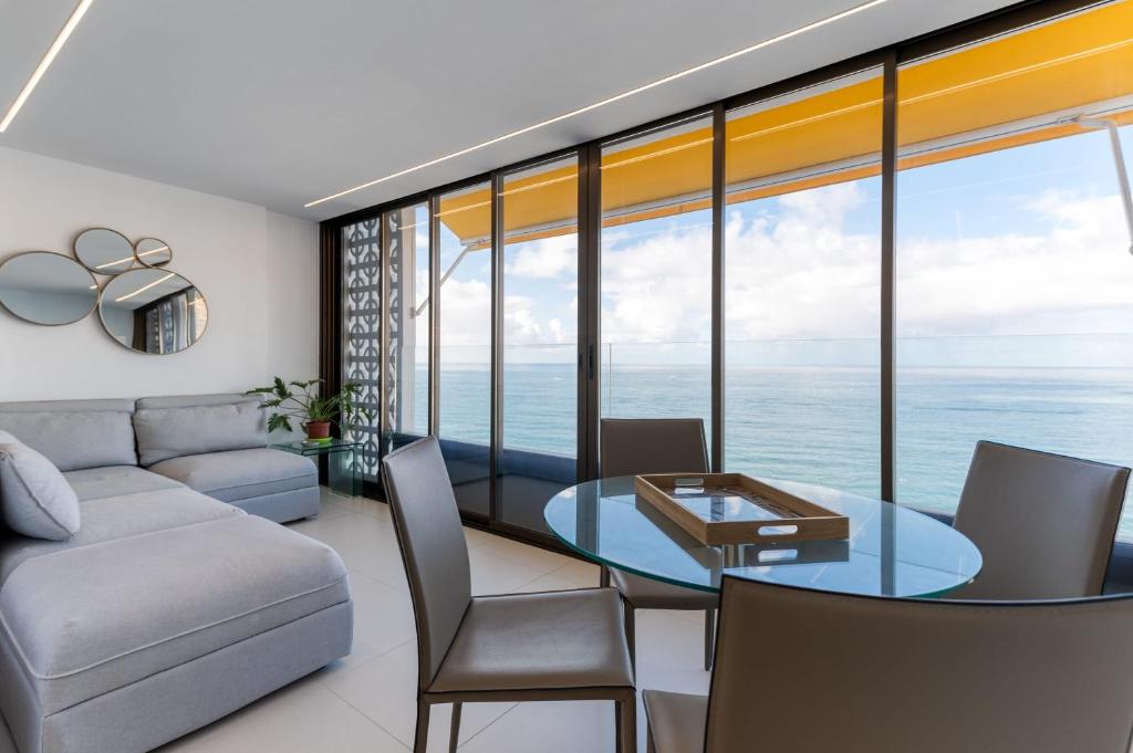 a living room with a couch and a table at Brand New - Ocean Views - Sunset Facing in Patalavaca